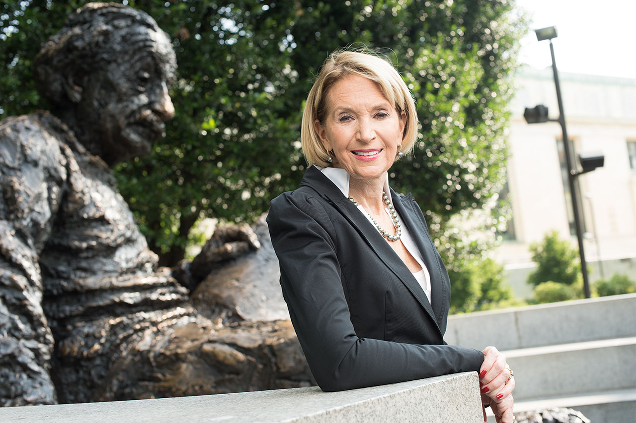 Marcia McNutt poses with the Albert Einstein monument outside of the National Academy of Sciences.